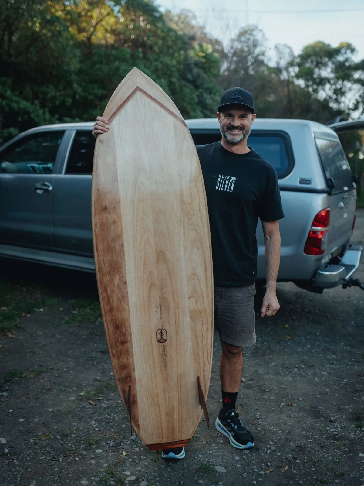 A finished hollow timber board held up outside the workshop
