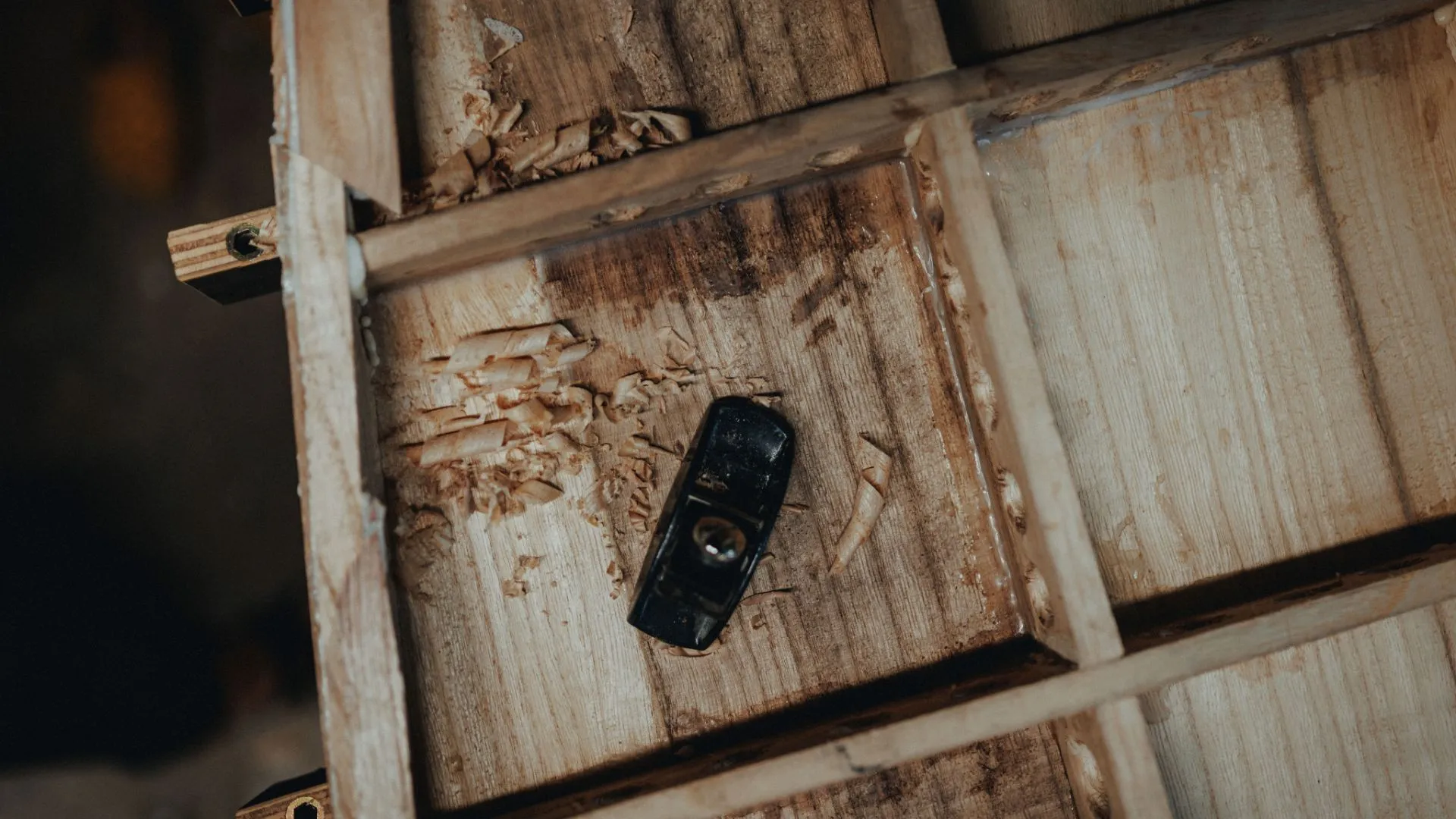 Shavings curling off a deck skin under a hand plane